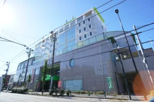 介護施設の建物外観。複数階建てのモダンな施設で、玄関前の広場が見える。
